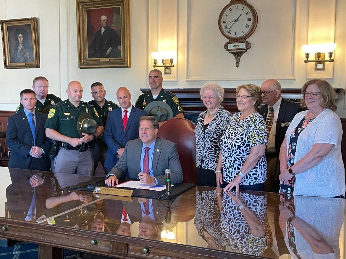 Gov. Chris Sununu signs bill naming a bridge in Portsmouth in honor of Staff Sergeant Jesse E. Sherrill, who died in the line of duty last fall on Interstate 95, on Wednesday.