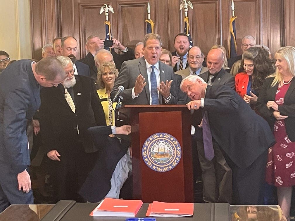 Gov. Chris Sununu is pictured at the broken podium Tuesday at the signing of the state budget at the Executive Council chamber at the State House.