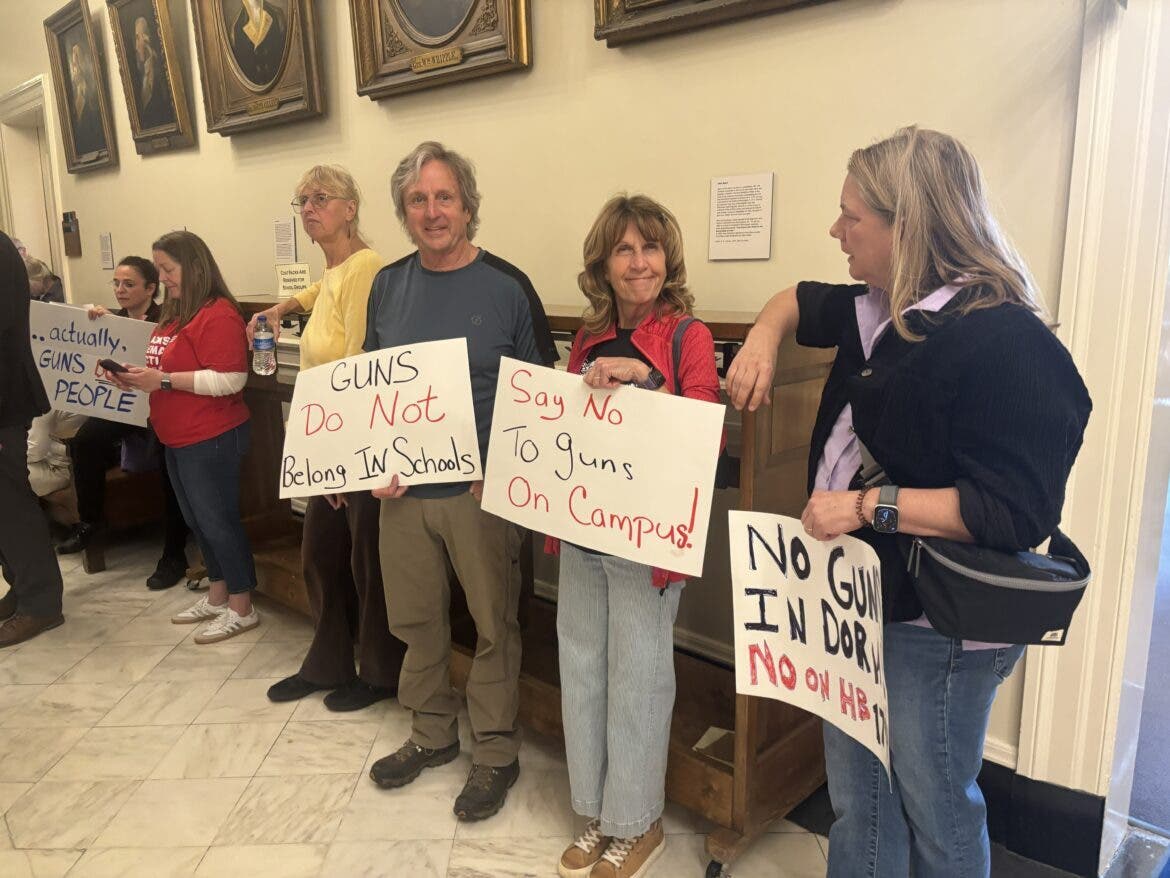 People opposed to guns in schools turned out for a committee hearing Tuesday at the State House. Holding the sign "Guns do not belong in schools" is Tim Moody of Lee. Next to him on his right is his wife Wynne Moody. Next to her is Amy Trafton of Durham.