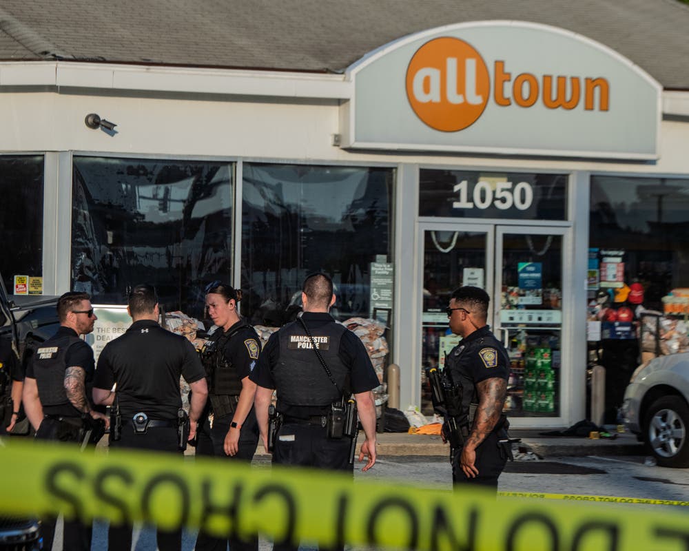 Police are pictured at the Manchester gas station where a man was found stabbed Monday.