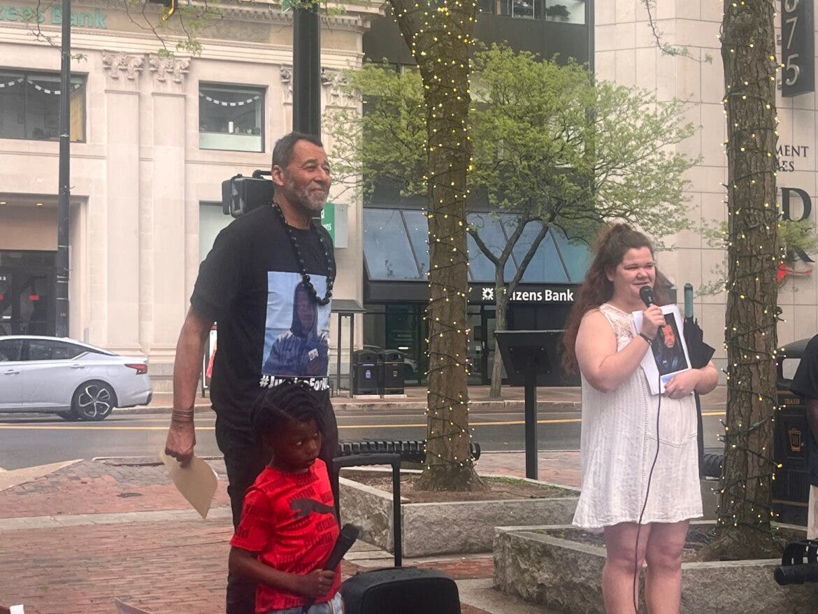 King Downing, director of the Healing Justice Program, stands beside Nikki Murray, Nickenley Turenne’s girlfriend who was with him the night he died. Turenne’s little brother, Wilson, stands with Downing at a news conference Tuesday.