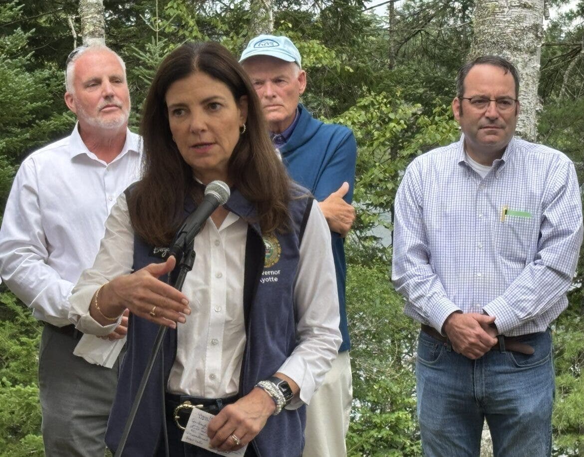 Gov. Kelly Ayotte signs new law at Forest Lake State Park Thursday. Behind her are Sen. Howard Pearl, Wayne Morrison, and Sen. David Rochefort.