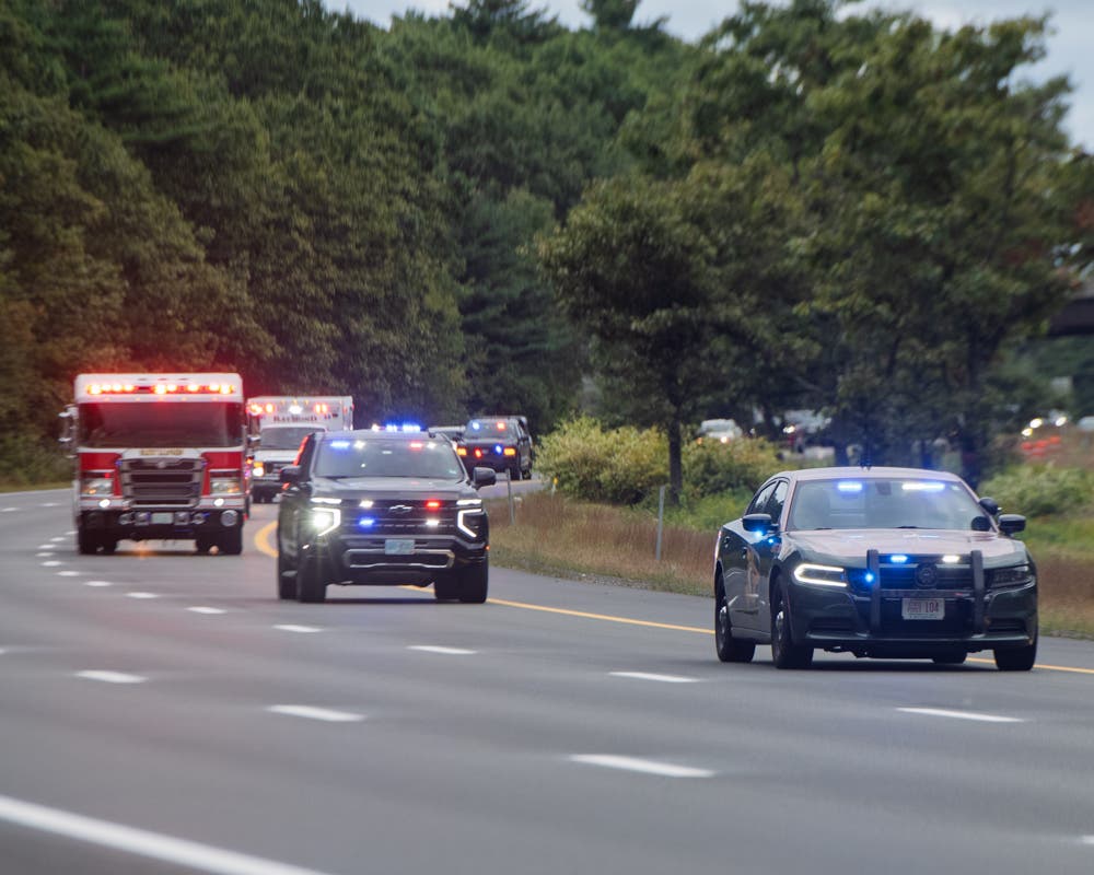 Fire departments set up apparatus on overpasses as Firefighter Eric Phillips's body was escorted from an Epping funeral home to the Office of the Chief Medical Examiner in Concord.