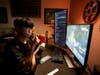 Florida Mayhem gaming team star FATE swabs his cheek while playing a video game, as star teammate Byrem looks on, as part of the first-ever nonprofit partnership of the Mayhem, the Misfits esports league, and Gift of Life Marrow Registry.