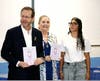 President Herzog and First Lady receiving a book from ninth grader Yarin Kabri (right) at ISTS Danciger High School, who wrote about her experience dealing with hearing impairment
