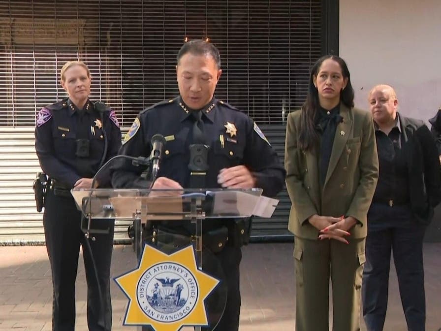 San Francisco Police Chief Derrick Lew speaks at a press conference outside the Warfield Theatre as District Attorney Brooke Jenkins (center) looks on, Oct. 7, 2026.