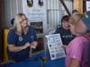 Maj Tina Peterson, CAP, at left, demonstrates a sling psychrometer to girls at the Women in Aviation Day. Her lessons explained the role that weather plays in aviation.