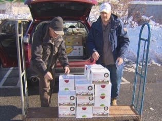 Stu McNeil and John Tierney load food into a car.