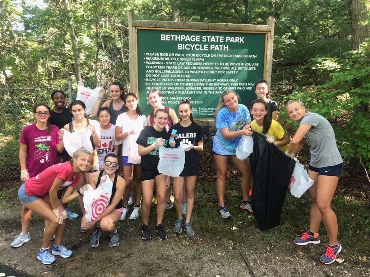 The FHS girls’ cross-country team get ready to collect trash as they train.