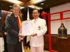 Rhode Island Lieutenant Governor Daniel Mckee, left, is presented with a Certificate of Honor by Dr. Hong, Tao-Tze, president of FOWPAL, after ringing the Bell of World Peace and Love in New York. 