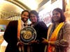 Former President of Mauritius Ameenah Gurib-Fakim, center, on behalf of Dr. Hong, Tao-Tze, President of FOWPAL, presents the compass clock of conscience to Dr. Ash Pachauri, left, and a conscience scarf to Dr. Shonali Pachauri.