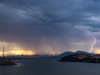 Lightning tears through the sky above the bay.