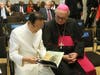 Dr. Hong, Tao-Tze, president of FOWPAL, left, shares a book with Bishop Camillo Ballin, Apostolic Vicar of Northern Arabia, during the World Leader Summit of Love and Peace. The book, titled “Be the Spark,” serves as a fine tool for conscience education. 