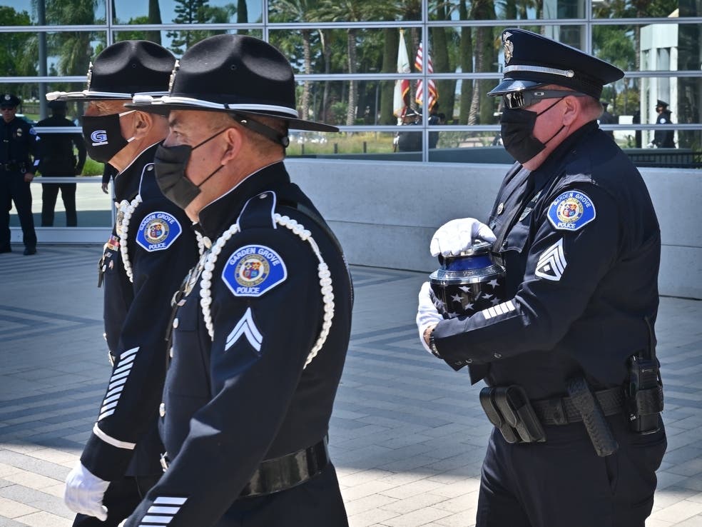 The ashes of Garden Grove Police Lt. John Reynolds are carried out of Christ Cathedral.