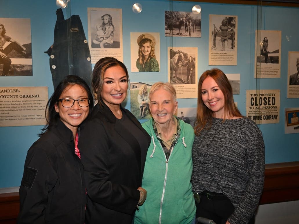 Current and former police officers with Dorothy Alice Chandler, 93, Orange County’s first female Sheriff’s Deputy in front of a display at the Old Orange County Courthouse celebrating her life. 