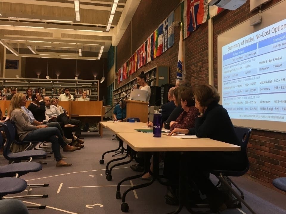 School committee members listen as Kristin Kissane argues for delaying any decision on start times.
