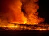 A firefighter battles the Kincade Fire near Geyserville, California on Thursday, Portions of Northern California remain in the dark after Pacific Gas & Electric cut power to prevent wildfires from sparking during dry and windy conditions.