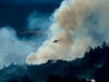 A helicopter passes a smoke plume as the Kincade Fire burns in unincorporated Sonoma County, Calif., on Thursday, Oct. 24, 2019.