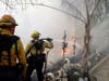 Firefighters make a stand as a wildfire approaches the backyard of a home Thursday, Oct. 24, 2019, in Santa Clarita, Calif.