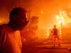 A man walks past a burning home during the Getty fire on Monday in Los Angeles.