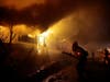 Firefighters try to hose down flames as homes burn in the Getty fire area along Tigertail Road on Monday in Los Angeles.