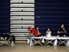 Evacuees from the Tick Fire sit on cots inside the gym at West Ranch High School on Friday in Santa Clarita, California.