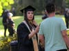 A woman attempts to take graduation photos as police stand behind her during a protest against police violence at the State Capitol in Sacramento, June 1, 2020.