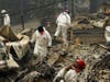 In this Nov. 13, 2018, file photo, search and rescue workers search for human remains at a trailer park burned out from the Camp Fire in Paradise, Calif. 
