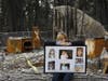 In this Feb. 7, 2019, file photo, Christina Taft, the daughter of Camp Fire victim Victoria Taft, displays a collage of photos of her mother, at the burned out ruins of the Paradise, Calif., home where she died in 2018.