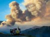 A firefighter from Carpinteria monitors the huge plume from the out-of-control Apple fire along Bluff Street, north of Banning during the coronavirus pandemic on August 1, 2020 in Cherry Valley, California.