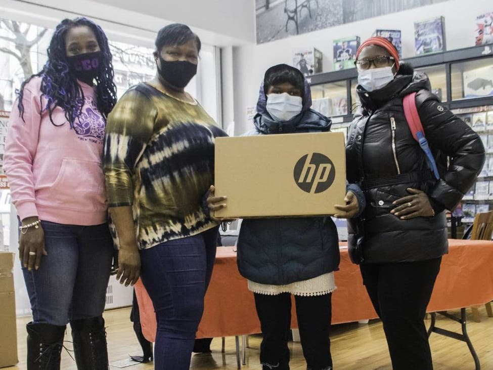 Stewart (second from left) during a laptop giveaway by Harlem Initiative for Students in Need at P.C. Richard on 125th Street.