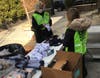 Organizers Zaki Molvi (left) and Lindsey Cormack distribute gloves and socks on Friday outside the Bentley Hotel on East 62nd Street.