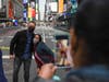 Tourists pose for a photo in Times Square on May 8, 2021 in New York City. According to reports, three people, including a toddler, were injured in a shooting near West 44th St. and Seventh Ave.