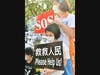 A little girl asks for help from the international community as she holds a sign that reads “Please Help Us!” in front of the enforcement agency in Miao-Li, Taiwan on August 21, 2020.