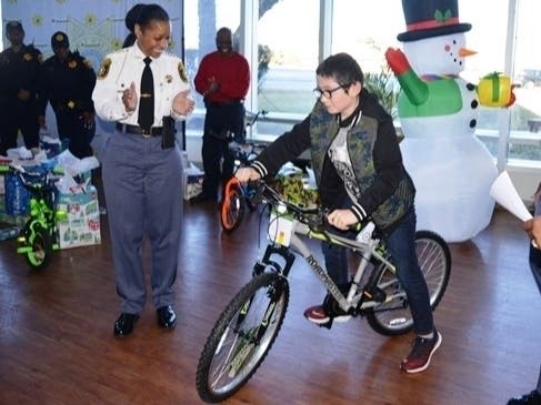 DeKalb Sheriff Melody Maddox joins Chief Deputy Randy Akies and Chaplain Curtis Crocker to distribute toys at the agency’s 14th Annual Adopt-A-Family Holiday Party. 