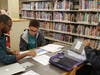 An IMANI Tutor helps a student with science homework.
