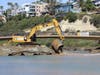 Construction crews remove temporary water culverts beneath the new permanent trail footbridge at San Elijo.