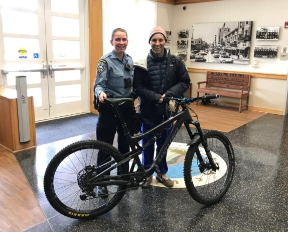 The patient poses with a community service office who helped reunite him with his bike.