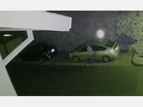 A man checks a car door handle in a Pleasanton apartment complex.