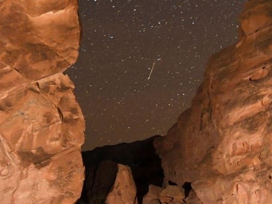 A Geminid meteor streaks between peaks of the Seven Sisters rock formation early in 2018, in the Valley of Fire State Park in Nevada. The meteor display is known as the Geminid meteor shower because it appears to radiate from the constellation Gemini.