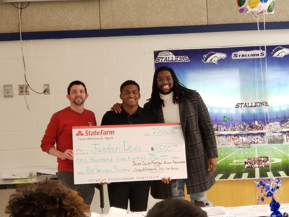 South County High School student Jaeden Davis, center, is awarded a $1,500 scholarship from State Farm Agent Casey Whitmarsh, left, and SCFAA Vice President and former South County star player Devin Vandyke.