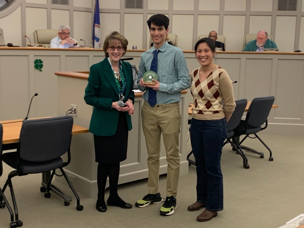Leesburg resident Tycho Svoboda, center, received a top environmental award Tuesday from Mayor Kelly Burk, left, and Jennifer Chu, chair of the town's EAC.