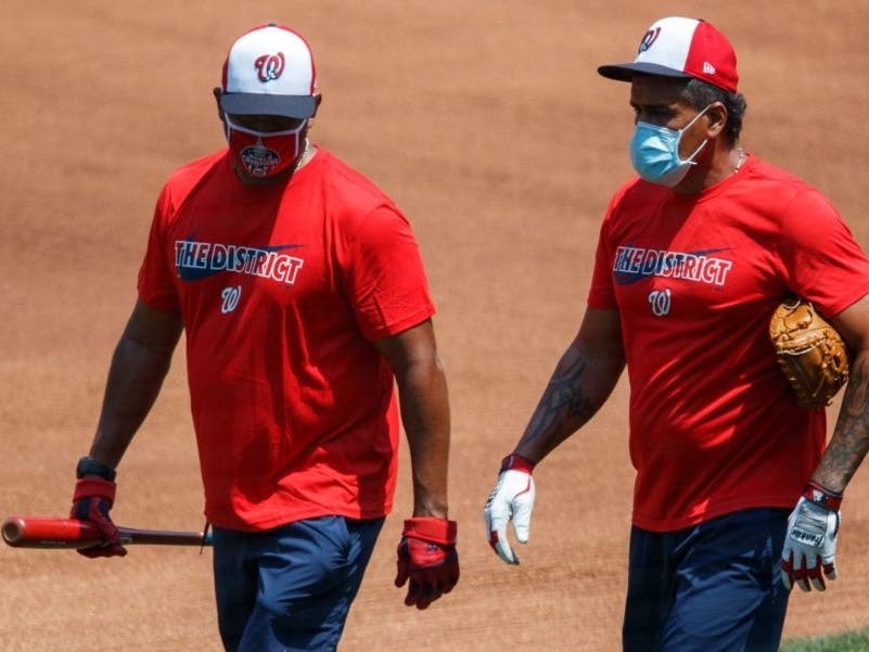 Washington Nationals’ manager Dave Martinez, left, and bullpen coach Henry Blanco walk together during a workout at Nationals Park on Sunday.