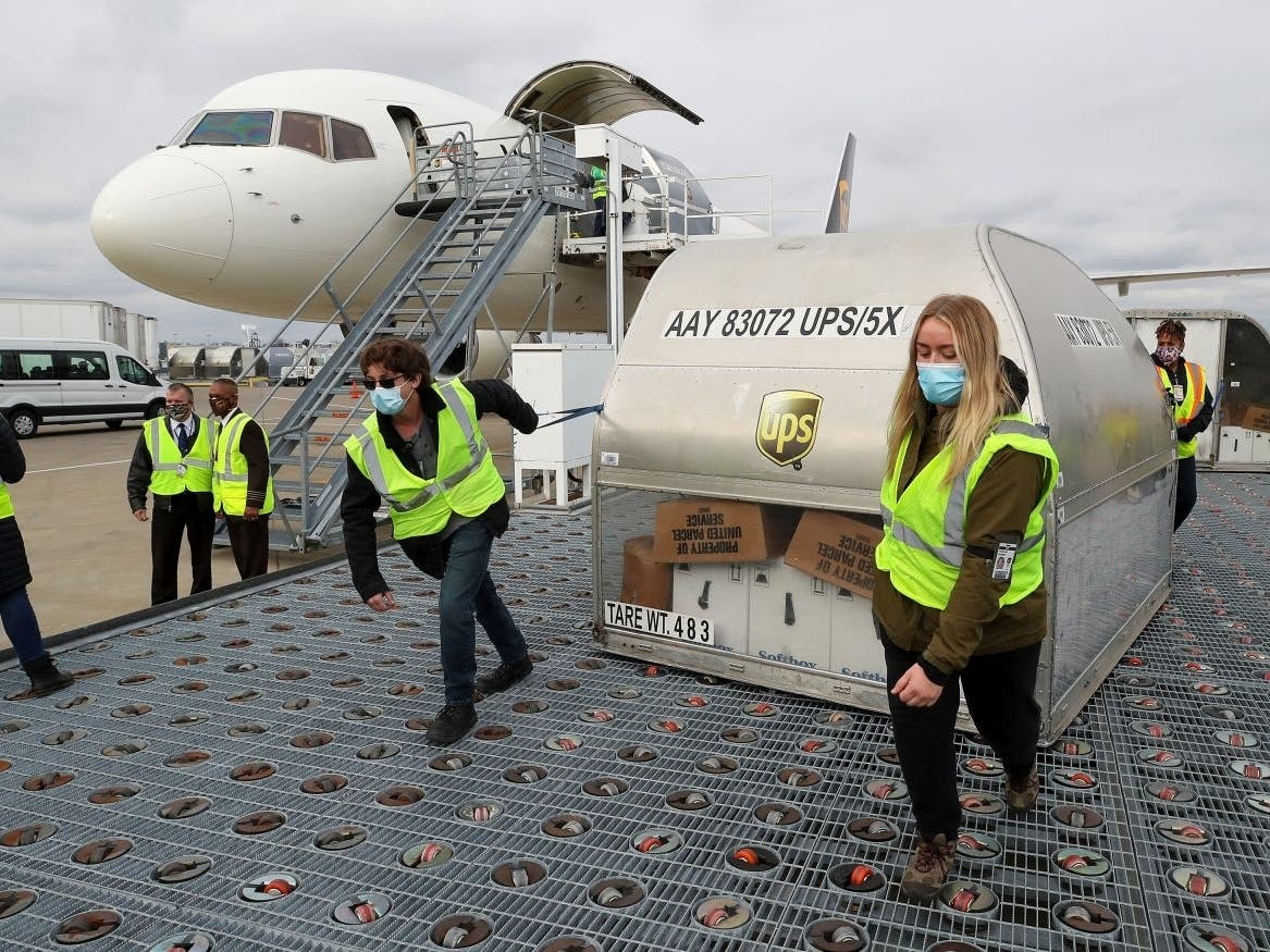 UPS employees move the first shipments of the Pfizer COVID-19 vaccines on a ramp at a UPS facility in Louisville, Kentucky, on Dec. 13, 2020.