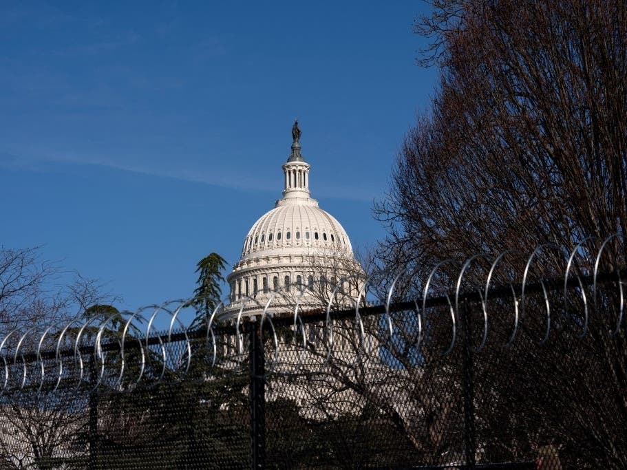 Barbed wire is installed on security fencing surrounding the U.S. Capitol on Jan. 14 following the breach of the building on Jan. 6.