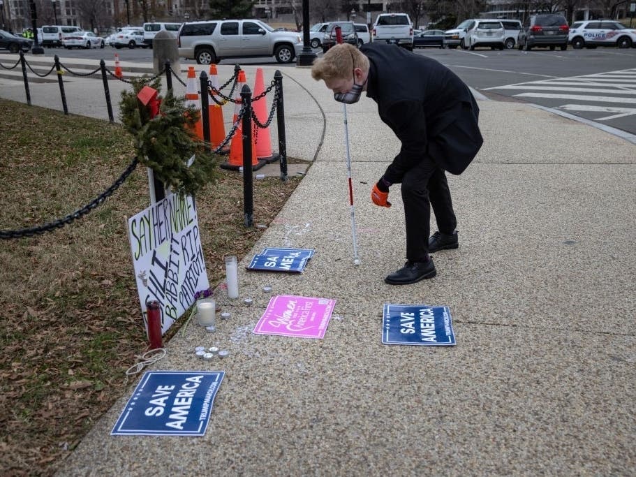 A visitor looks at a makeshift shrine to Ashli Babbitt, 35, outside the U.S. Capitol on Jan. 8. Babbitt was shot and killed while storming the Capitol on Jan. 6. She traveled from California to DC to support President Trump.