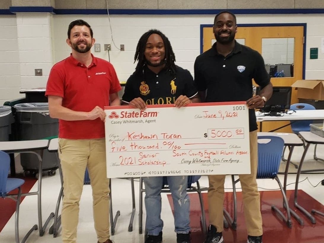 South County High School senior Keshawn Toran, middle, receives $5,000 scholarship award from State Farm Agent Casey Whitmarsh, left, and South County Football Alumni Association President Marlon Dubuisson.
