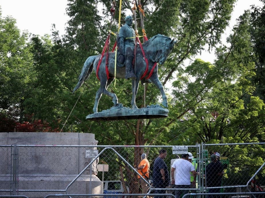 Workers remove a statue of Confederate Gen. Robert E. Lee from Market Street Park on Saturday in Charlottesville. Initial plans to remove the statue four years ago sparked the “Unite the Right” rally where 32-year-old Heather Heyer was killed.