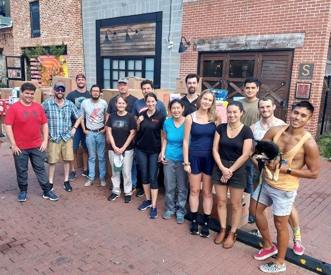 Dalton Dwinell, vice commander of VFW Post 9274 (back row, with goatee), and Dave Crance, chaplain of Post 9274 (back row, wearing blue hat), with volunteers from other VFW posts and universities during a break while loading donations for Afghan refugees.