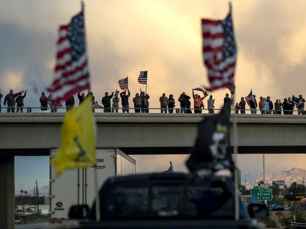 Supporters cheer on a trucker caravan heading toward the Washington, D.C., area to protest COVID-19 mandates on Feb. 23 in Needles, Calif.